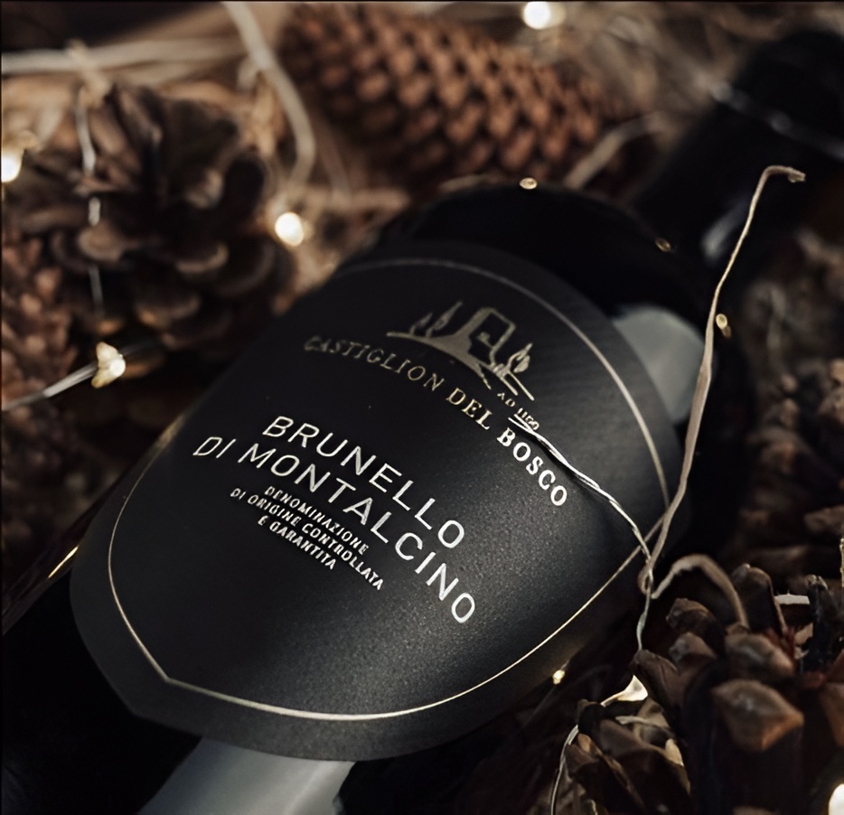  A close-up of a bottle of Castiglion del Bosco Brunello di Montalcino wine nestled among pine cones and fairy lights.