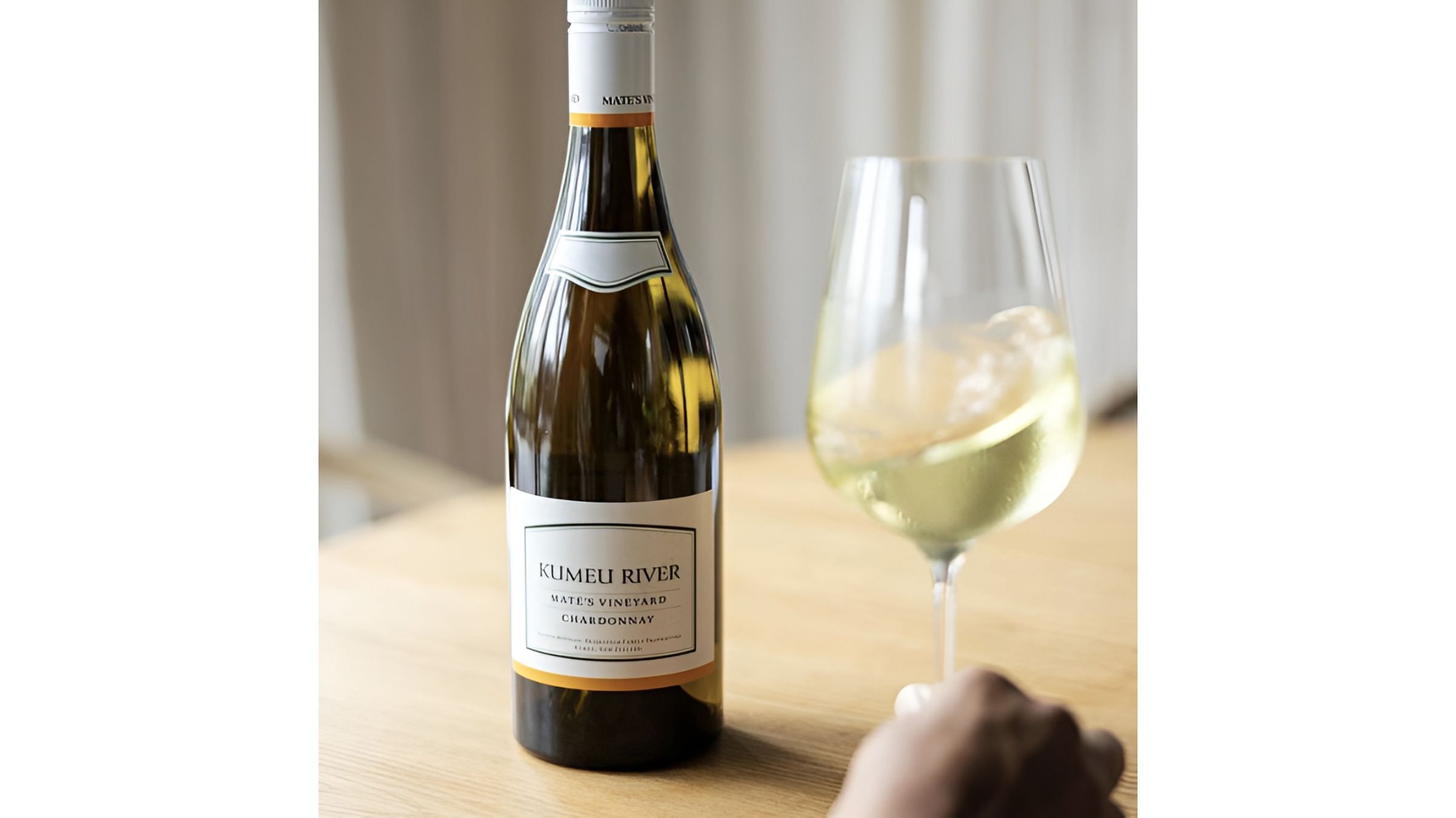 Chilled Chardonnay bottle and white wine glass on a table in soft natural light, clicked at WHWC.