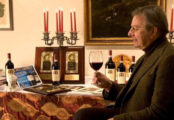 Vintage wine bottle being uncorked at a candlelit dinner and held by an old man in the picture. 