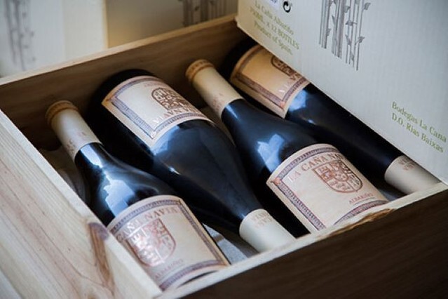 Wooden crate filled with bottles of Spanish red wine labeled La Caña Navia Albariño.